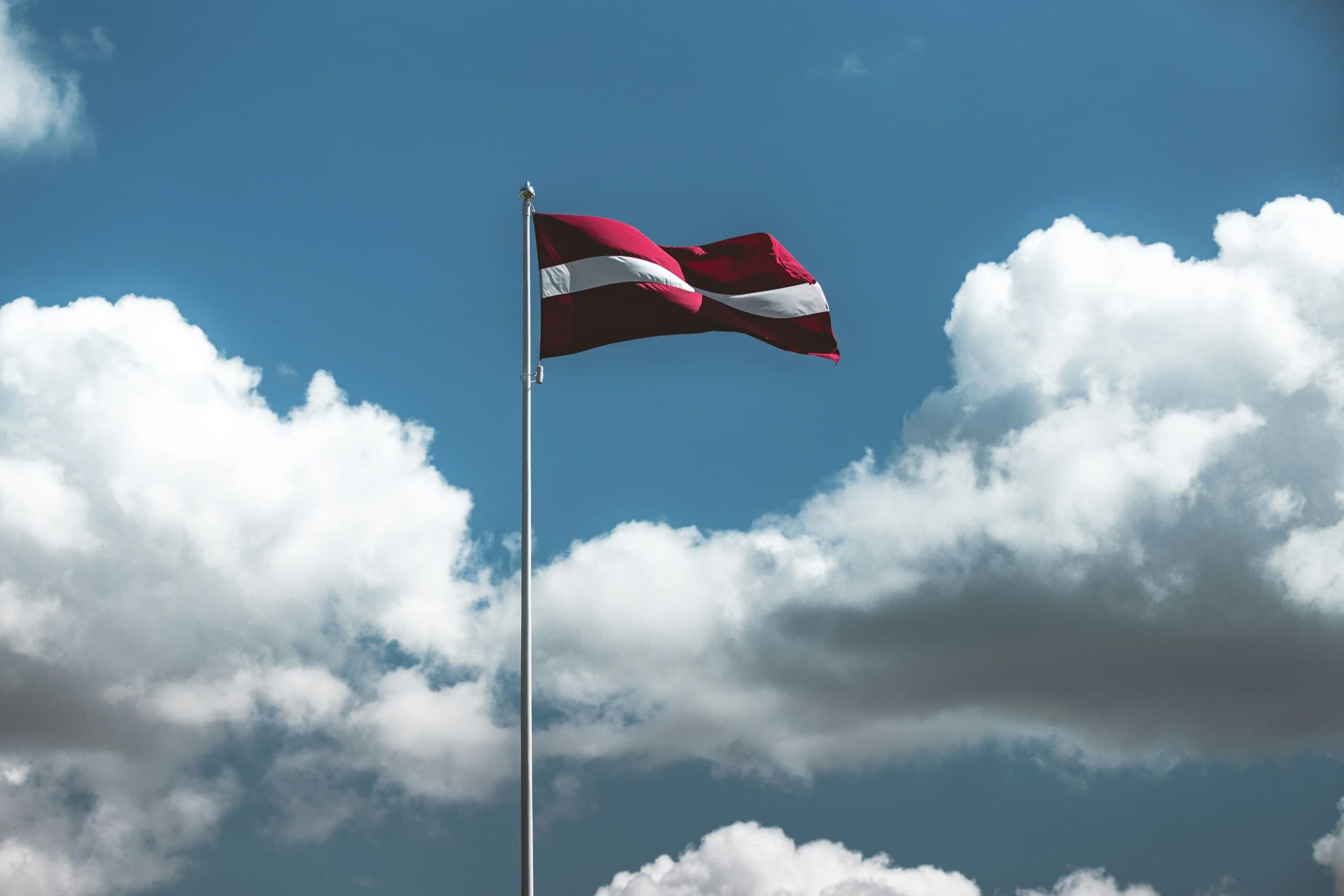 National flag of Latvia waving in the sky.